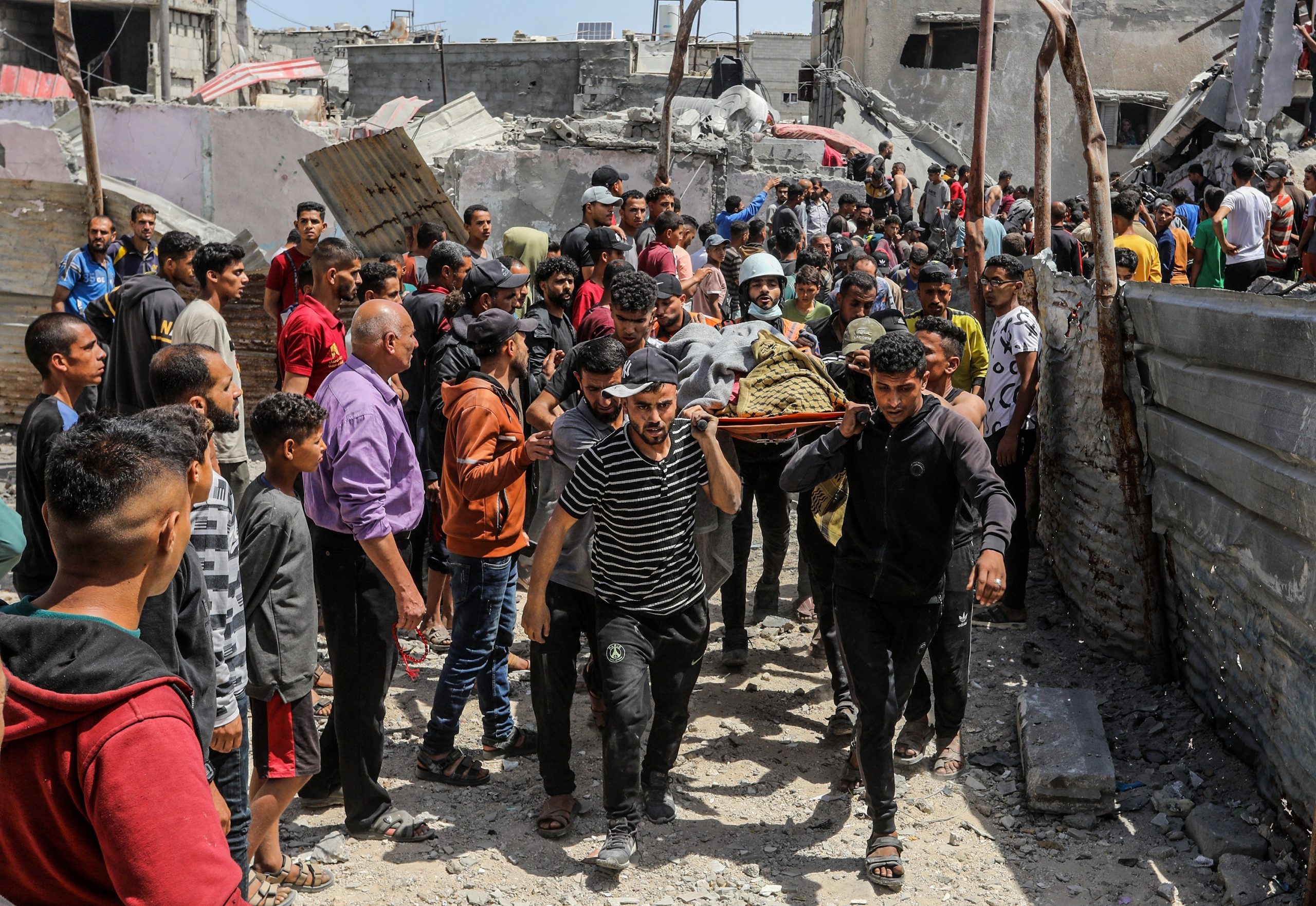 1 Mayıs 2025 | Gazze Şeridi’nin güneyindeki Han Yunus’ta çok sayıda eve düzenlenen bir İsrail hava saldırısının ardından, Filistinliler yaralıları ve hayatını kaybedenleri yıkımın yaşandığı yerden taşıyor. | Fotoğraf: Anas Mohammed